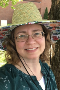 Headshot of Rebecca Seipelt-Thiemann outdoor with a tree and building the background