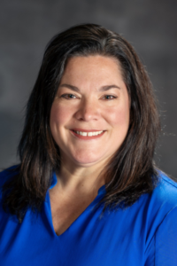 Headshot of Jennifer Vannatta-Hall against a dark gray background.